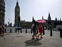 Pedestrians walk in the midday sun past the Palace of Westminster in central London on September 6, 2023 as the late summer heatwave continues.