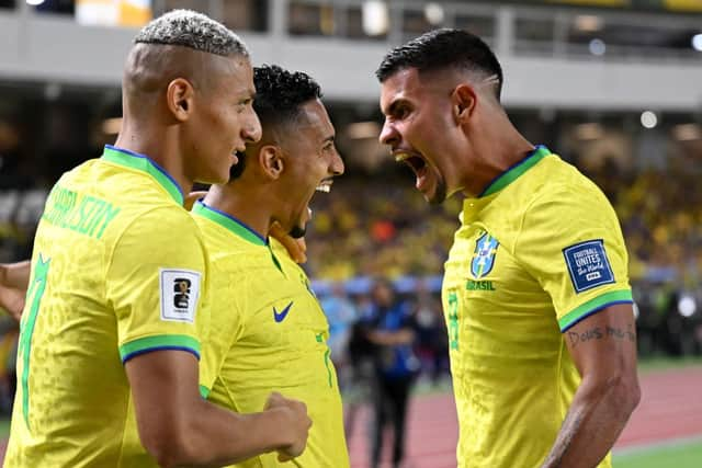 Brazil's forward Raphinha (C) celebrates with teammates forward Richarlison (L) and midfielder Bruno Guimaraes after scoring a goalduring the 2026 FIFA World Cup South American qualifiers football match between Brazil and Bolivia at the Jornalista Edgar ProenÃ§a 'Mangueirao' stadium, in Belem, state of Para, Brazil, on September 8, 2023. (Photo by CARL DE SOUZA / AFP) (Photo by CARL DE SOUZA/AFP via Getty Images)