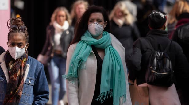 A woman wears a face mask while walking on Oxford Street.