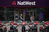 Pedestrians walk past a branch of a NatWest bank in London.