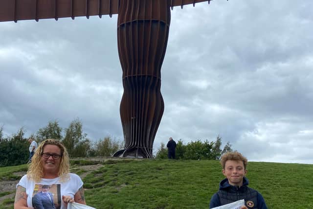 Angie and son Callum, holding the banner at The Angel of the North 
