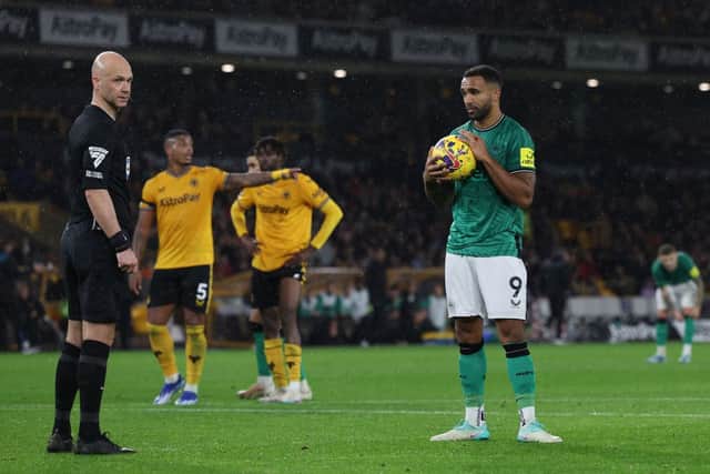 English referee Anthony Taylor (L) and Newcastle United striker Callum Wilson (R) wait for the VAR decision before a penalty is given. (Photo by Adrian DENNIS / AFP) 