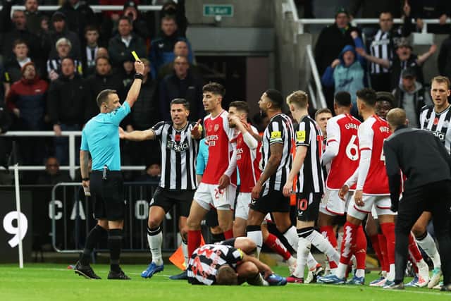 NEWCASTLE UPON TYNE, ENGLAND - NOVEMBER 04: Referee, Stuart Attwell shows a yellow card to Kai Havertz of Arsenal during the Premier League match between Newcastle United and Arsenal FC at St. James Park on November 04, 2023 in Newcastle upon Tyne, England. (Photo by Ian MacNicol/Getty Images)