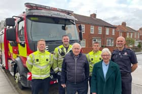 crew members from Blue Watch at South Shields Community Fire Station pictured in-front of a fire appliance with Syd McDonald and friend Ann Powell