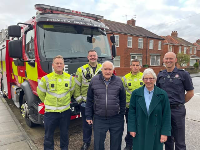 crew members from Blue Watch at South Shields Community Fire Station pictured in-front of a fire appliance with Syd McDonald and friend Ann Powell