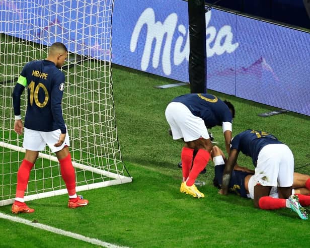 Paris Saint-Germain midfielder Warren Zaire-Emery down injured whilst playing for France. (Photo by VALERY HACHE/AFP via Getty Images)