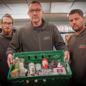 CEO Peter Maloney (middle) with team members Joe and Johnny showcasing a typical food parcel
Credit: Wayne Madden of Hospitality and Hope