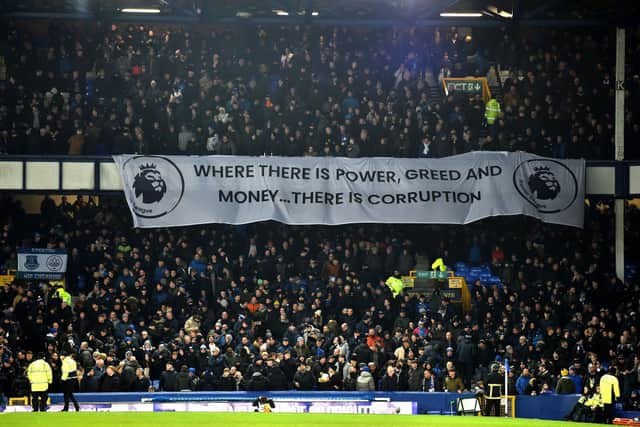 Everton fans unveil an anti-Premier League protest banner ahead of the English Premier League football match between Everton and Newcastle United at Goodison Park in Liverpool, north west England on December 7, 2023. (Photo by PETER POWELL / AFP)