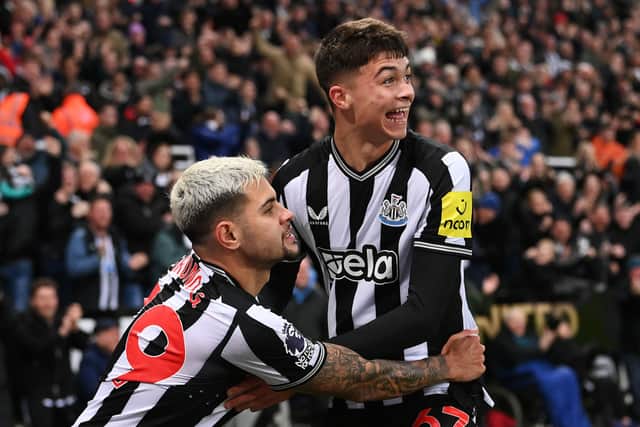 Lewis Miley of Newcastle United (R) celebrates with teammate Bruno Guimaraes after scoring their team's first goal during the Premier League match between Newcastle United and Fulham FC at St. James Park on December 16, 2023 in Newcastle upon Tyne, England. (Photo by Stu Forster/Getty Images)