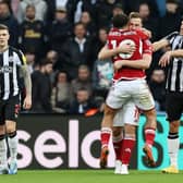 Chris Wood of Nottingham Forest celebrates with team mate Morgan Gibbs-White after scoring their sides third goal during the Premier League match between Newcastle United and Nottingham Forest at St. James Park on December 26, 2023 in Newcastle upon Tyne, England. 