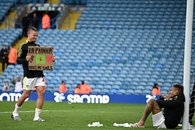 Leeds United's English midfielder Kalvin Phillips brings a placard over to Leeds United's Brazilian midfielder Raphinha Dias Belloli as players interact with fans after the English Premier League football match between Leeds United and Brighton and Hove Albion at Elland Road in Leeds in 2022. 