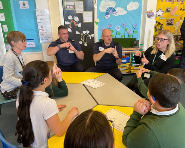 TWFRS Watch Manager Steven Walker and firefighter Paul O'Neil are shown ‘simple signs’ by young people and staff from Broadwood Primary School HIARP and Jesmond Park Academy HIARP.