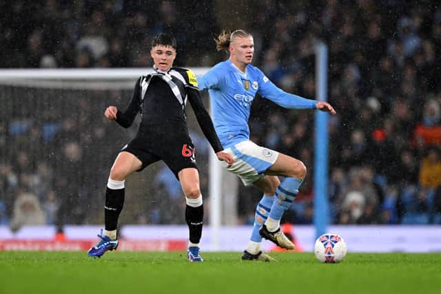 Erling Haaland of Manchester City rips the shirt of Lewis Miley of Newcastle United whilst battling for possession during the Emirates FA Cup Quarter Final match between Manchester City and Newcastle United at Etihad Stadium on March 16, 2024 in Manchester, England. (Photo by Stu Forster/Getty Images)