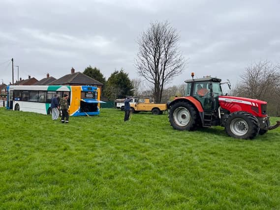 A tractor pulling along the bus