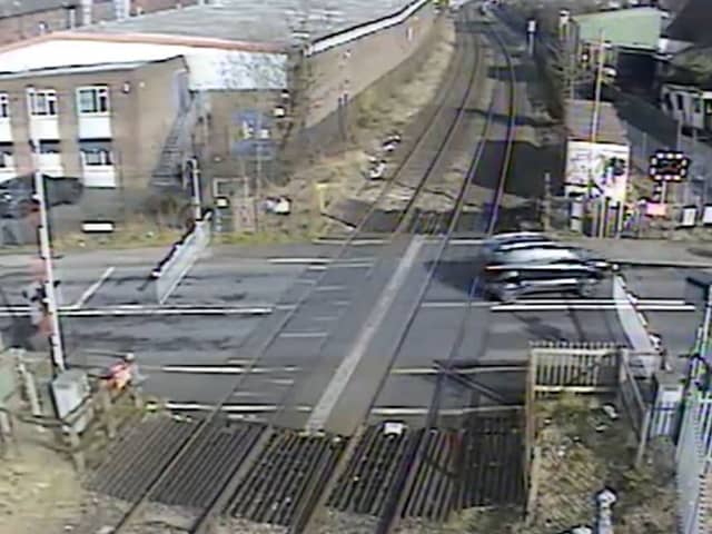 A car ignoring the signals and crossing the other side of the road to quickly dodge the closing barriers (Langley Green level crossing, West Midlands).  