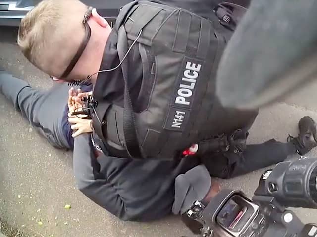 Deraj Meade being arrested by armed police.  