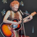 Helen Russell performing with her guitar