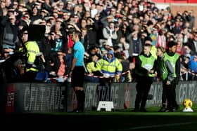 Stuart Attwell checking the VAR monitor during a Premier League match. 