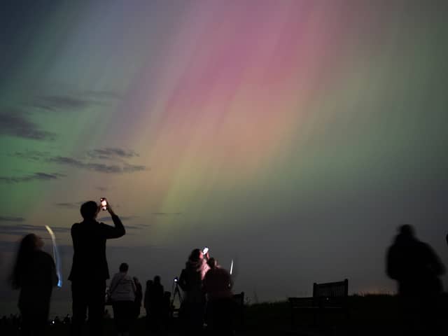 People visit St Mary's lighthouse in Whitley Bay to see the aurora borealis on 10 May 2024 (Photo: Ian Forsyth/Getty Images)