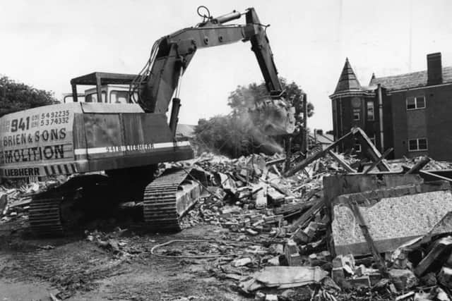 A digger clears another load of bricks and mortar away from the Ingham Infirmary in June 1991.