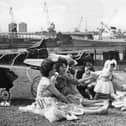 Under the shadow of the ships and cranes of Swan Hunters shipyard, a Hebburn family enjoy a picnic in the King George playing fields in 1964. 