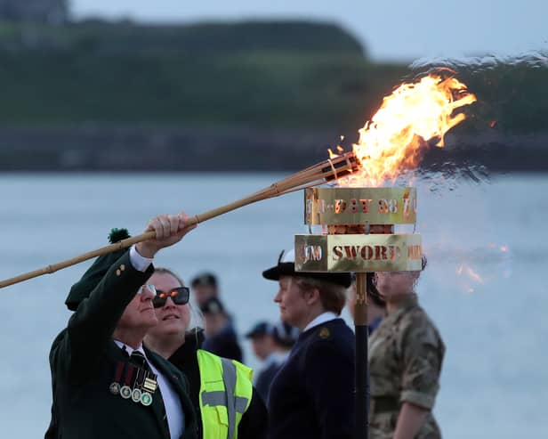 Veteran Joe Mills, Chair of South Tyneside NAAFI Break, lights beacon on Littlehaven Beach.