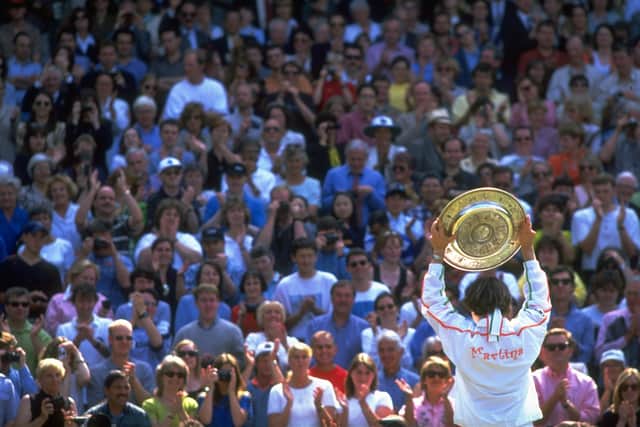 5 Jul 1997:  Martina Hingis of Switzerland holds the trophy aloft to show the spectators after her victory in the Women's Singles final against Jana Novotna of the Czech Republic during the Lawn Tennis Championships at Wimbledon in London. (Credit: Clive Brunskill/Allsport for Getty Images)