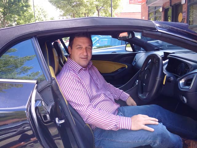 Conman Stephen Rae pictured in his Aston Martin.