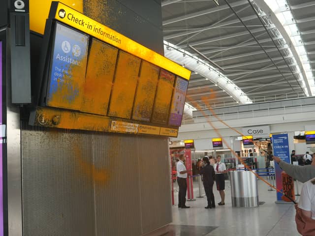 Just Stop Oil cover Heathrow Airport Terminal 5's departure boards in orange paint.