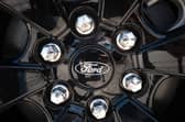 The Ford logo is shown on the wheel of a car. (Photo by Scott Olson/Getty Images)