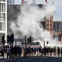 Smoke billows as police officers face off protesters in Liverpool on August 3, 2024 during the 'Enough is Enough' demonstration held in reaction to the fatal stabbings in Southport on July 29.