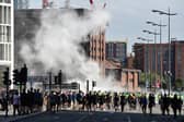 Smoke billows as police officers face off protesters in Liverpool on August 3, 2024 during the 'Enough is Enough' demonstration held in reaction to the fatal stabbings in Southport on July 29.