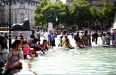 People cool off from the heat at the fountains of Trafalgar square, in central London. (Photo: HENRY NICHOLLS/AFP via Getty Images)