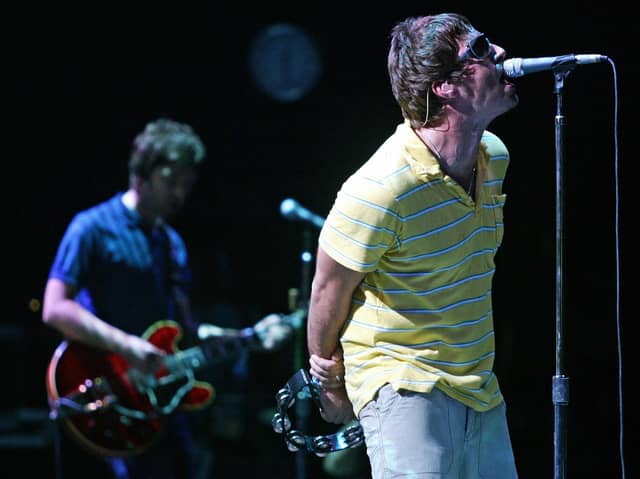 Liam (R) and Noel Gallagher perform on stage. Photo: JOSE JORDAN/AFP via Getty Images