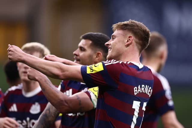 Harvey Barnes of Newcastle United celebrates scoring his team's second goal with teammates during the Premier League match between Wolverhampton Wanderers FC and Newcastle United FC at Molineux on September 15, 2024 in Wolverhampton, England.