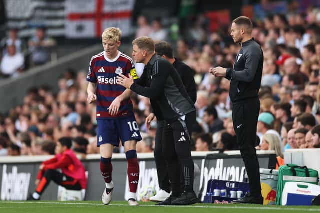 Eddie Howe, Manager of Newcastle United, speaks to Anthony Gordon of Newcastle United during the Premier League match between Fulham FC and Newcastle United FC at Craven Cottage on September 21, 2024 in London, England.