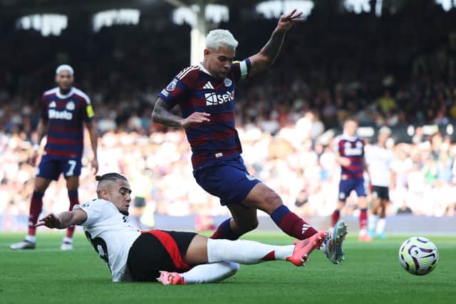 Andreas Pereira of Fulham is challenged by Bruno Guimaraes of Newcastle United during the Premier League match between Fulham FC and Newcastle United FC at Craven Cottage on September 21, 2024 in London, England.