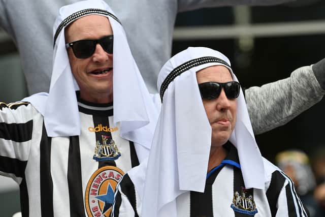 Newcastle United supporters celebrate the Saudi-backed takeover outside of St James' Park on October 7, 2021