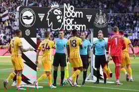 Brighton & Hove Albion players shake hands with match officials in front of the 'No Room for Racism' handshake board prior to the Premier League match between Fulham FC and Aston Villa FC at Craven Cottage on October 19, 2024 in London, England. (Photo by Matt McNulty/Getty Images)