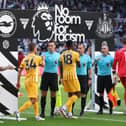 Brighton & Hove Albion players shake hands with match officials in front of the 'No Room for Racism' handshake board prior to the Premier League match between Fulham FC and Aston Villa FC at Craven Cottage on October 19, 2024 in London, England. (Photo by Matt McNulty/Getty Images)