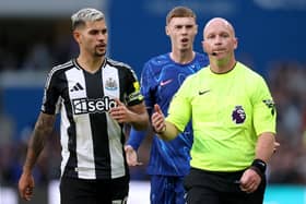 Cole Palmer of Chelsea and Bruno Guimaraes of Newcastle United react towards Referee Simon Hooper after he reverses his original decision of 'penalty' following a VAR review during the Premier League match between Chelsea FC and Newcastle United FC at Stamford Bridge on October 27, 2024 in London, England. (Photo by Ryan Pierse/Getty Images)