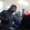 Moment armed robber in Halloween mask raids shop till.