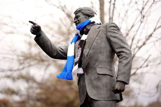 A detailed view of the statue of Sir Bobby Robson on the outside of the stadium, featuring a match-day scarf which shows the emblems of Ipswich Town and Newcastle United, prior to the Premier League match between Ipswich Town FC and Newcastle United FC at Portman Road on December 21, 2024 in Ipswich, England. (Photo by Paul Harding/Getty Images)