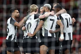 Newcastle United's Swedish striker #14 Alexander Isak (R) is mobbed by teammates after scoring the opening goal during the English Premier League football match between Manchester United and Newcastle United at Old Trafford in Manchester, north west England, on December 30, 2024. (Photo by Darren Staples / AFP) 