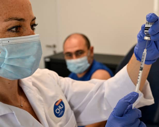 A nurse prepares to give a patient the mpox vaccine. 
