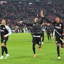 Frankfurt's Egyptian forward #07 Omar Marmoush (L), Frankfurt's French forward #11 Hugo Ekitike (C) and Frankfurt's German forward #36 Ansgar Knauff (R) celebrate with the fans after winning the German first division Bundesliga football match VfB Stuttgart vs Eintracht Frankfurt. (Photo by THOMAS KIENZLE/AFP via Getty Images)