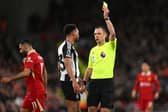 Stuart Attwell booking Jacob Murphy during Liverpool's win over Newcastle United