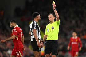 Stuart Attwell booking Jacob Murphy during Liverpool's win over Newcastle United
