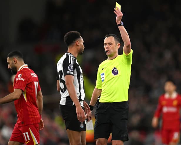 Stuart Attwell booking Jacob Murphy during Liverpool's win over Newcastle United