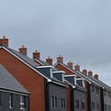 An electricity pylon is pictured beyond newly built residential properties at a construction site for new houses and homes near Aylesbury in July 2023 (Photo: JUSTIN TALLIS/AFP via Getty Images)